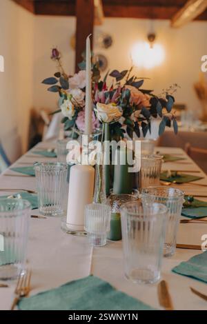 Ein stilvoller und durchdacht gestalteter Tisch mit Kerzen, Blumen und elegantem Geschirr. Stockfoto