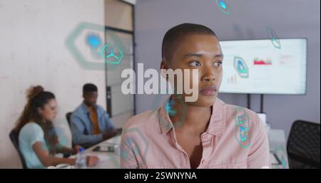 Bild von ökologischen Symbolen über verschiedene Kollegen, die im Büro arbeiten Stockfoto