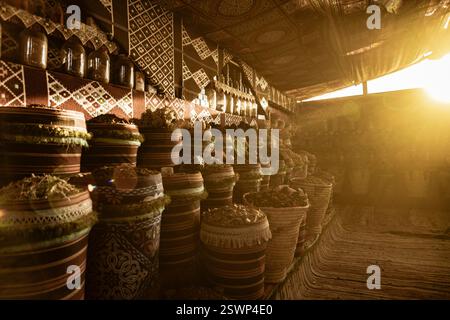 Sonnenlicht zieht durch einen Wüstenmarkt in marsa alam und beleuchtet lebendige, gemusterte Körbe mit verschiedenen Gewürzen und Kräutern Stockfoto