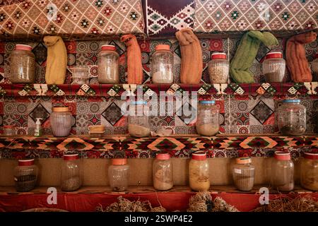 Farbenfrohe Gläser mit Gewürzen und Kräutern sind auf gemusterten Regalen in einem traditionellen Marktplatz in der Wüste marsa alam, ägypten, angeordnet Stockfoto