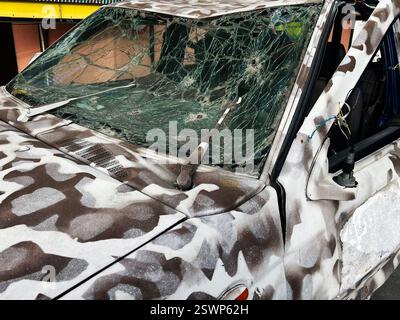 Zerbrochene Windschutzscheibe für Militärfahrzeuge und beschädigtes Äußere mit Tarnfarbe im Detail Stockfoto