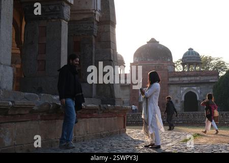 Eine indische Frau fotografiert ihren männlichen Begleiter neben Isa Khans Grab, das Teil des Humayun's Tomb Complex aus der Mogulzeit in Neu-Delhi ist Stockfoto