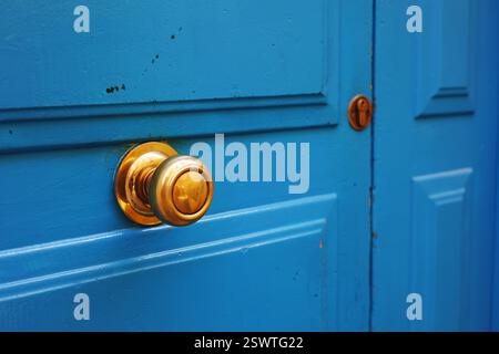 Blaue Holztür und goldener Griff Stockfoto