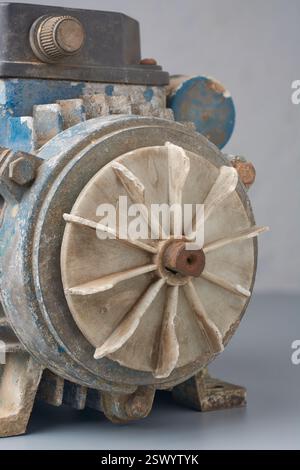 Nahaufnahme des Kühlgebläses mit Kunststoffklingen, die an der alten Rostwasserpumpe befestigt sind, saugt Luft an, zirkuliert um die Pumpe und leitet Wärme ab Stockfoto