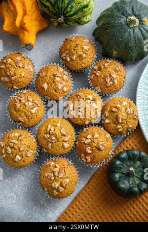 Kürbis Gewürz Cupcakes, Kürbispüree Backwaren, Kürbisse, Küchentuch, grauer Hintergrund. Muffins mit Kürbis und Nüssen Stockfoto