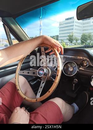 Vilnius, Litauen - 01.07.2020 - Mann, der einen alten Ford Mustang GT350 Shelby Cobra aus den 1960er Jahren mit einem hölzernen Lenkrad fährt, Innenansicht Stockfoto