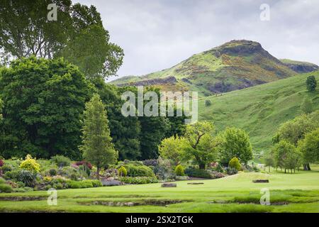 Üppige grüne Gärten des Holyroodhouse Palace in Edinburgh, Großbritannien, mit Arthurs Sitz im Hintergrund, die die Natur und landschaftliche Schönheit von Scotlands zeigen. Stockfoto