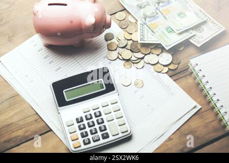 Sparkasse mit Bargeld und Taschenrechner auf dem Hintergrund von Geschäftsdokumenten Stockfoto