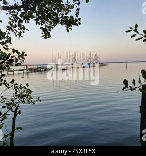 Eine wunderschöne und ruhige Waterfront-Szene mit eleganten Segelbooten vor dem Sonnenuntergang Stockfoto