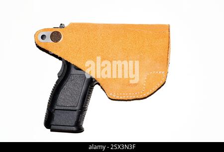 Schwarze halbautomatische Pistole in Lederholster, weißer Hintergrund, Seitenansicht. Stockfoto