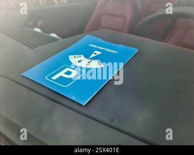Auf dem Armaturenbrett des Fahrzeugs angezeigte Parkscheibe, die die Ankunftszeit anzeigt, nützlich für Parkzonen mit zeitlicher Begrenzung Stockfoto