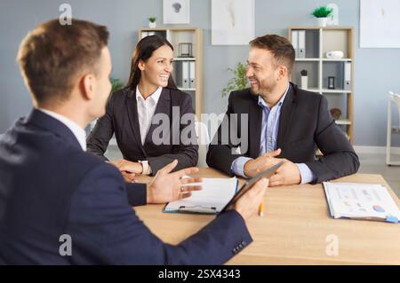Geschäftsmann Finanzberater berät junge Paare, die am Arbeitsplatz im Büro sitzen. Stockfoto
