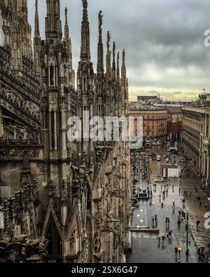 Blick auf den Innenhof von Il Duomo, vom Dach. Der Eingang zum Einkaufszentrum Galleria Vittorio Emanuele ist die bogenförmige Öffnung zum ri Stockfoto