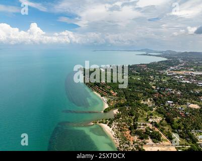 Malerische Küste mit üppig grünen Landschaften und klarem türkisfarbenem Meer unter einem bewölkten Himmel. Koh Samui, Thailand. Stockfoto