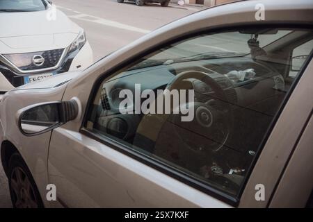 Cremona, Italien, 9. Februar 2025 Beige Fiat Idea 1,3 Multijet parkte neben einem weißen Nissan Leaf in einer bezaubernden Straße in Cremona und zeigt URBAN I Stockfoto