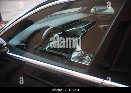 Cremona, Italien 9. Februar 2025 Moderne schwarze Audi A8 L parkt in Cremona, Italien, mit Armaturenbrett und Lenkrad durch das Fenster Stockfoto