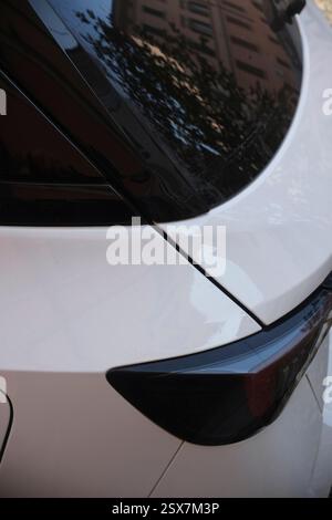 Cremona, Italien, 9. Februar 2025 Nahaufnahme des Hecks eines weißen Opel Mokka, das das schlanke Design des Rücklichts und die Reflexion eines Gebäudes unterstreicht Stockfoto