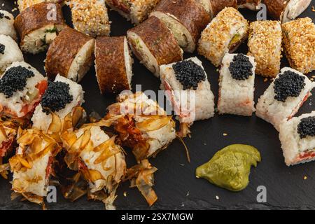 Die köstliche Sushi-Platte zeigt eine Vielzahl von wunderschön angeordneten Sushi-Brötchen, garniert mit Kaviar und garniert mit Wasabi. Perfekt für einen Celebrato Stockfoto