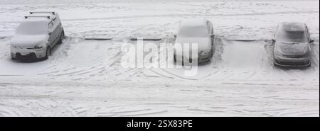Autos parken im Winter unter Schnee Stockfoto