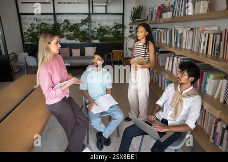 Multiethnische Schulkameraden nehmen an Bildungsseminaren in der Bibliothek Teil Stockfoto