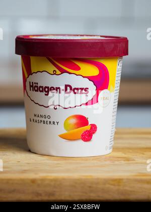 Swinton, Manchester, Großbritannien, 15. Februar 2025: Tub of Haagen Dazs Mango and Himbeereis. Stockfoto