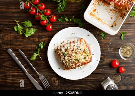 Hausgemachte Lasagne mit Hackfleisch, Ricotta und Tomatensauce auf weißem Teller auf Holztisch. Draufsicht, flach Stockfoto