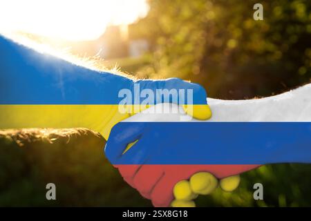 Bayern, Deutschland - 23. Februar 2025: FOTOMONTAGE, ein Handschlag zwischen der Ukraine und Russland symbolisiert Hoffnung auf Frieden. Trotz der tiefen Konflikte der Länder könnte Diplomatie den Weg zu einem Abkommen ebnen *** FOTOMONTAGE, ein Handschlag zwischen Ukraine und Russland symbolisiert Hoffnung auf Frieden. Trotz tiefe Konflikten der Länder könnte Diplomatie den Weg zu einer Einigung ebnen. Stockfoto