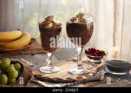 Zwei Tassen Chia Schokoladenpudding mit frischen Bananen am Morgen. Gesundes Frühstück. Stockfoto