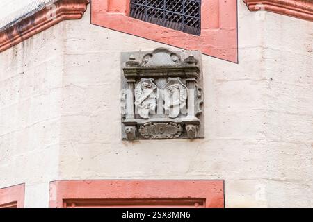 Ein Steinrelief zeigt ein Wappen mit zwei Tierköpfen, wahrscheinlich Löwen, einer Ziege und dem Datum 1603. Sie ist an der hellbeigen Gebäudewand der Kaiserpfalz in Forchheim, Bayern, befestigt Stockfoto