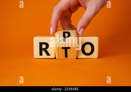 RPO vs. RTO-Symbol. Geschäftsmann-Hand dreht Holzwürfel und ändert das Wort RTO in RPO. Wunderschöner orangefarbener Hintergrund. Geschäftskonzept. Kopierbereich Stockfoto