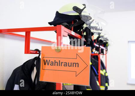 Bornhagen, Deutschland. Februar 2025. Ein Schild mit der Aufschrift „Wahlraum“ ist vor Feuerwehrhelmen in einer Wahlstation für die Bundestagswahl zu sehen. Die Vorwahl zum 21. Deutschen Bundestag findet am Sonntag statt. Quelle: Swen Pförtner/dpa/Alamy Live News Stockfoto