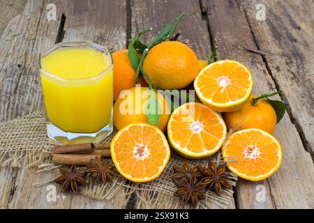 Orangensaft und einige frische Früchte auf hölzernem Hintergrund Stockfoto
