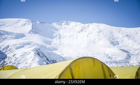 Expeditionszelte im Bergsteigercamp mit schneebedecktem Bergkamm, hoch oben in Pamir, Kirgisistan. Stockfoto