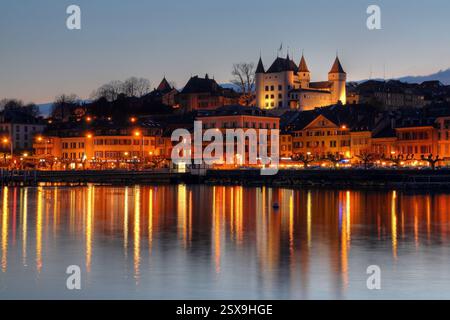 Die Stadt auf Nyon (etwa 25 km nördlich von Genf am Genfer See oder Leman, Schweiz) bei Sonnenuntergang, mit dem weißen Schloss von Nyon, das über der Stadt thront. Stockfoto
