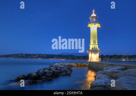 Nachtansicht auf den Leuchtturm Paquis in Genf, auf dem gleichnamigen See, Schweiz. Der Leuchtturm befindet sich an der Spitze eines Stegs, der von Ihnen gesäumt wird Stockfoto