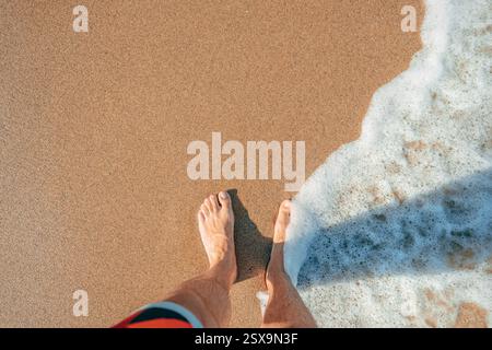 Erster Blick auf nasse Füße am Sandstrand während der Sommerferien, von oben nach unten Stockfoto