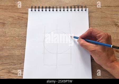 Handzeichnung Umrisse Personen Porträt mit blauem Bleistift in Skizzenbuchbindung auf dem Schreibtisch Stockfoto