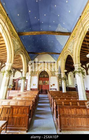 Die Kirche St. Andrew aus dem 14. Jahrhundert in Wickhambreaux. Innenansicht entlang der Mitte des Kirchenschiffs bis zur Turmtür. Einige mittelalterliche Gemälde an den Wänden. Stockfoto