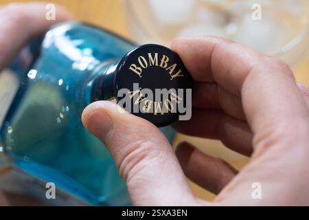 Die Hand des Mannes löst einen Schraubverschluss auf einer Flasche Bombay Sapphire Premium Spirit, einer Tochtergesellschaft von Bacaradi. UK Stockfoto