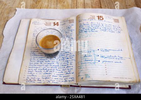 Eine Aufnahme von cremigem Espresso onan, altes handgeschriebenes Notizbuch Stockfoto