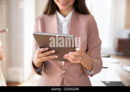 Abgeschnittene Nahaufnahme, die weibliche Mitarbeiterin mit einem digitalen Tablet erschossen hat Stockfoto