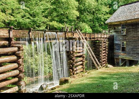 Holzhaus mit einer Leiter, die sich daran lehnt. Das Haus ist von einem Holzzaun umgeben. Im Hintergrund befindet sich ein Wasserfall Stockfoto