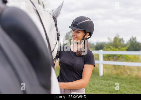 Weibliche Reiterhand streichelt sanft die wunderschöne dicke rote Pferdemäne, Nahaufnahme. Equitation und Tierliebhaber-Konzept. Stockfoto