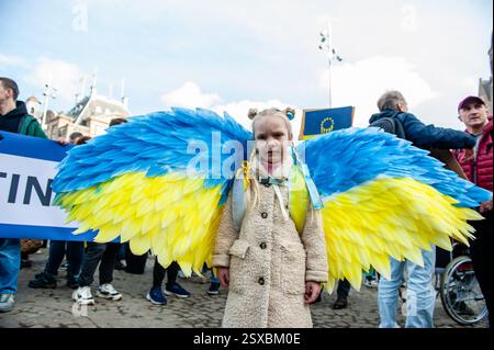 Amsterdam, Niederlande. Februar 2025. Ein ukrainisches Mädchen wird während der Demonstration mit blauen und gelben Flügeln gesehen. In Amsterdam versammelten sich Tausende ukrainischer Menschen, Unterstützer und ukrainische Soldaten, um die Gesellschaft daran zu erinnern, dass der Krieg beendet werden muss und dass die Ukraine Unterstützung braucht. Mehr als acht Millionen Menschen wurden gezwungen, die Ukraine zu verlassen, und weitere fünf Millionen wurden nach der russischen Invasion in der Ukraine vor drei Jahren Binnenvertriebene. Quelle: SOPA Images Limited/Alamy Live News Stockfoto