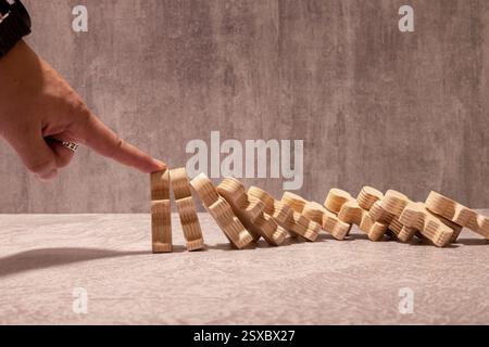 Versicherung mit Händen schützt Domino. Hände von Geschäftsleuten verhindern, dass Dominosteine in der Wirtschaftskrise fallen. Kontrolle und Planung von Geschäftsrisiken sowie Strategien für die Umsetzung Stockfoto
