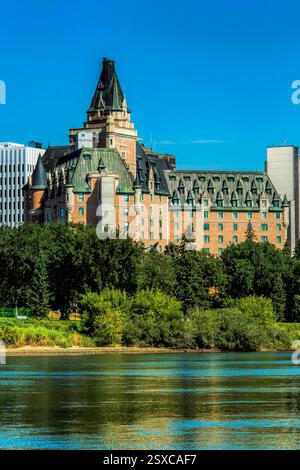 Großes Gebäude mit grünem Dach und einem hohen Turm. Das Gebäude ist von Bäumen und einem Gewässer umgeben Stockfoto
