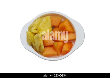 Frisch geschnittene Ananas- und Papaya-Stücke in einer weißen Schüssel isoliert auf weiß Stockfoto
