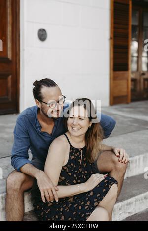 Paarportrait, Paare sitzen zusammen auf Steintreppen Stockfoto