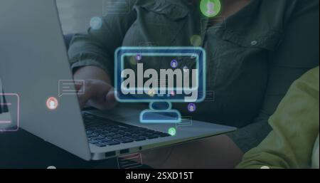 Bild von Computer- und Chat-Symbolen über zwei glückliche kaukasische Kollegen, die einen Laptop verwenden Stockfoto