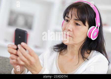 Glückliche Seniorin in Kopfhörern Stockfoto